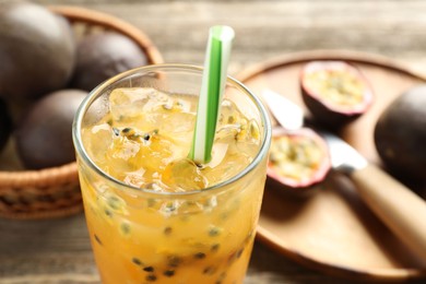 Photo of Tasty passion fruit drink and fresh fruits on wooden table, closeup