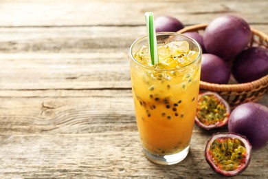 Photo of Tasty passion fruit drink and fresh fruits on wooden table, closeup. Space for text