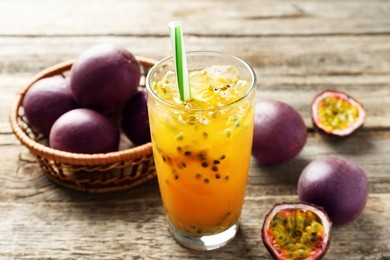 Photo of Tasty passion fruit drink and fresh fruits on wooden table, closeup