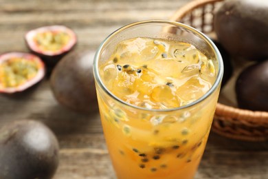 Photo of Tasty passion fruit drink and fresh fruits on wooden table, closeup