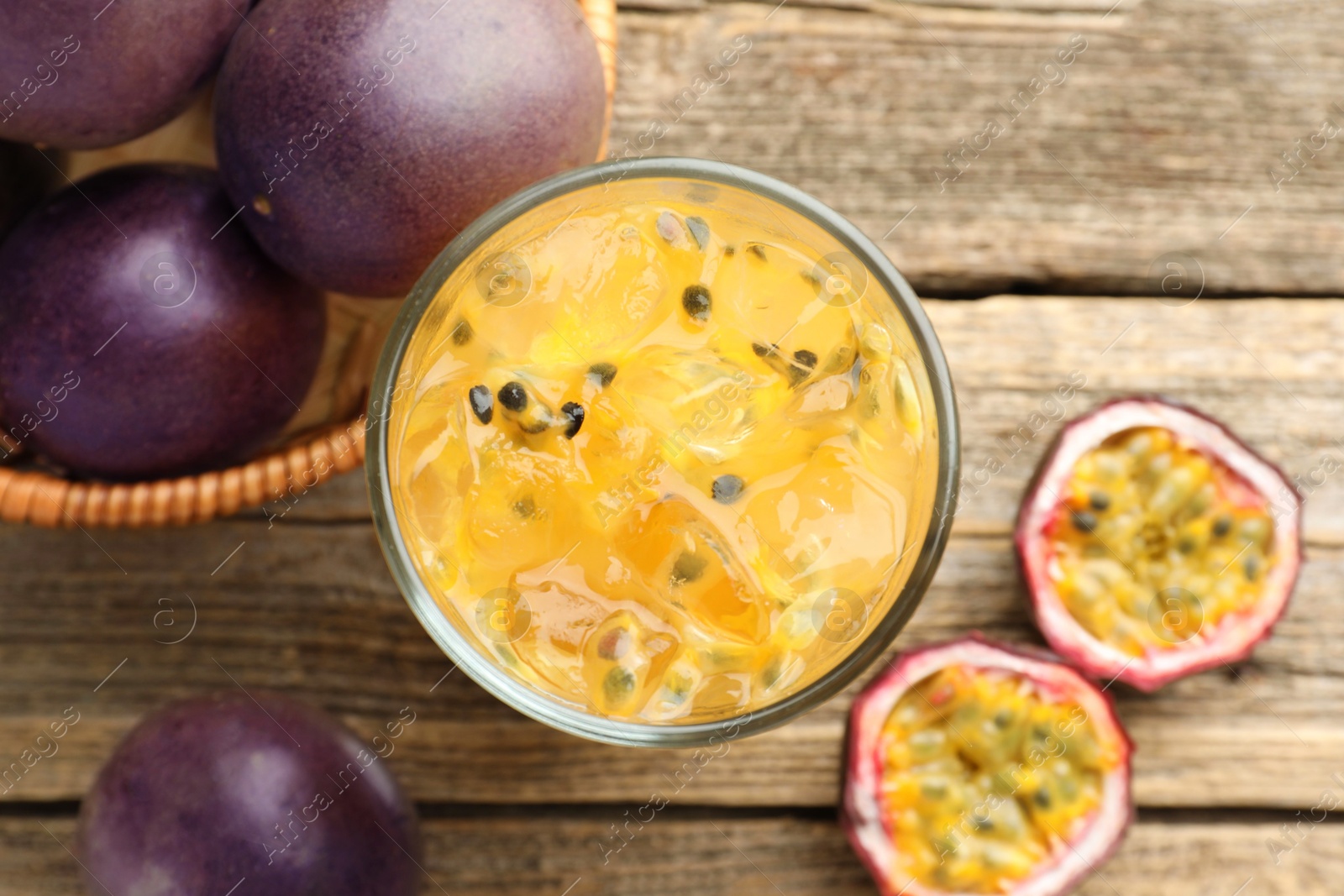 Photo of Tasty passion fruit drink and fresh fruits on wooden table, flat lay