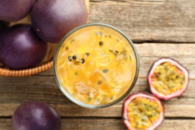 Photo of Tasty passion fruit drink and fresh fruits on wooden table, flat lay