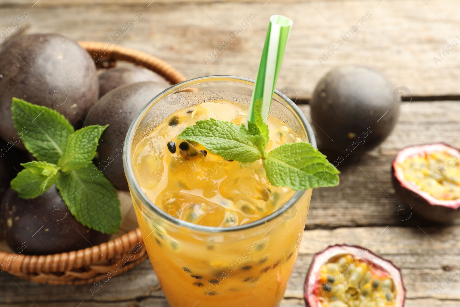Tasty passion fruit drink with mint and fresh fruits on wooden table, closeup Photo of Tasty passion fruit drink with mint and fresh fruits on wooden table, closeup