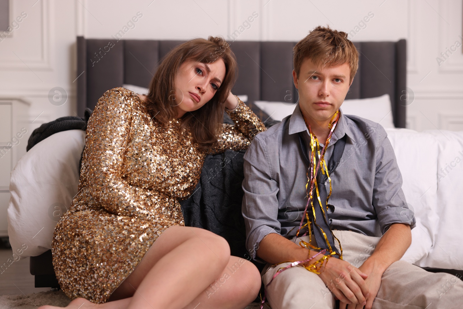 Photo of People suffering from hangover near bed indoors