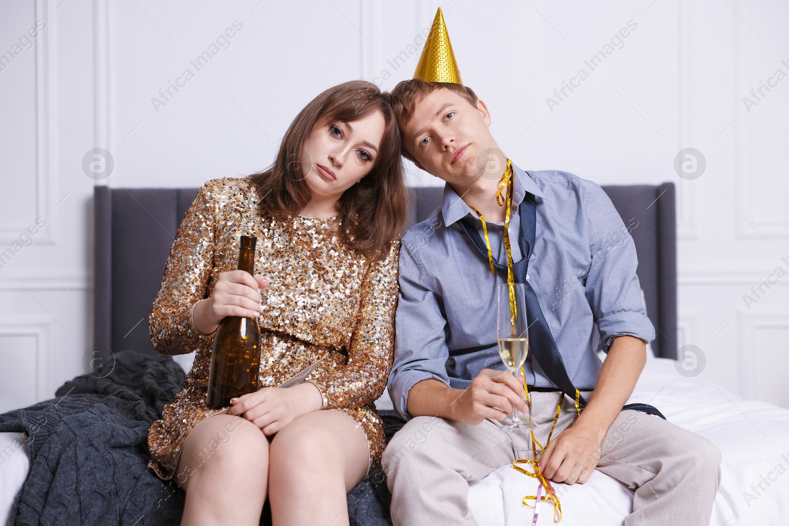 People with alcohol suffering from hangover on bed indoors Photo of People with alcohol suffering from hangover on bed indoors
