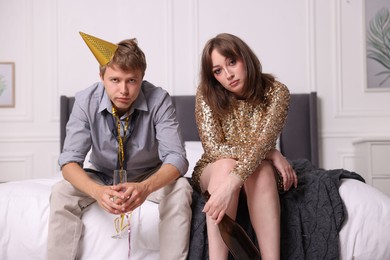 Photo of People with alcohol suffering from hangover on bed indoors