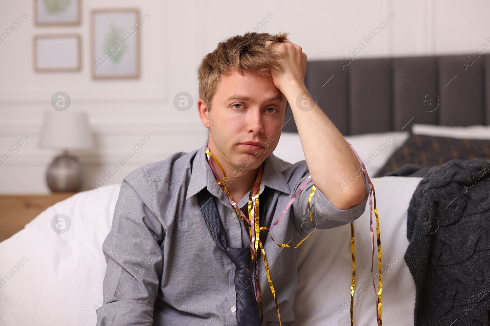 Man suffering from hangover near bed indoors Photo of Man suffering from hangover near bed indoors