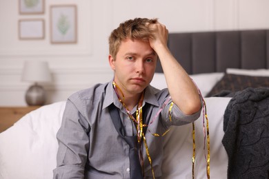 Photo of Man suffering from hangover near bed indoors