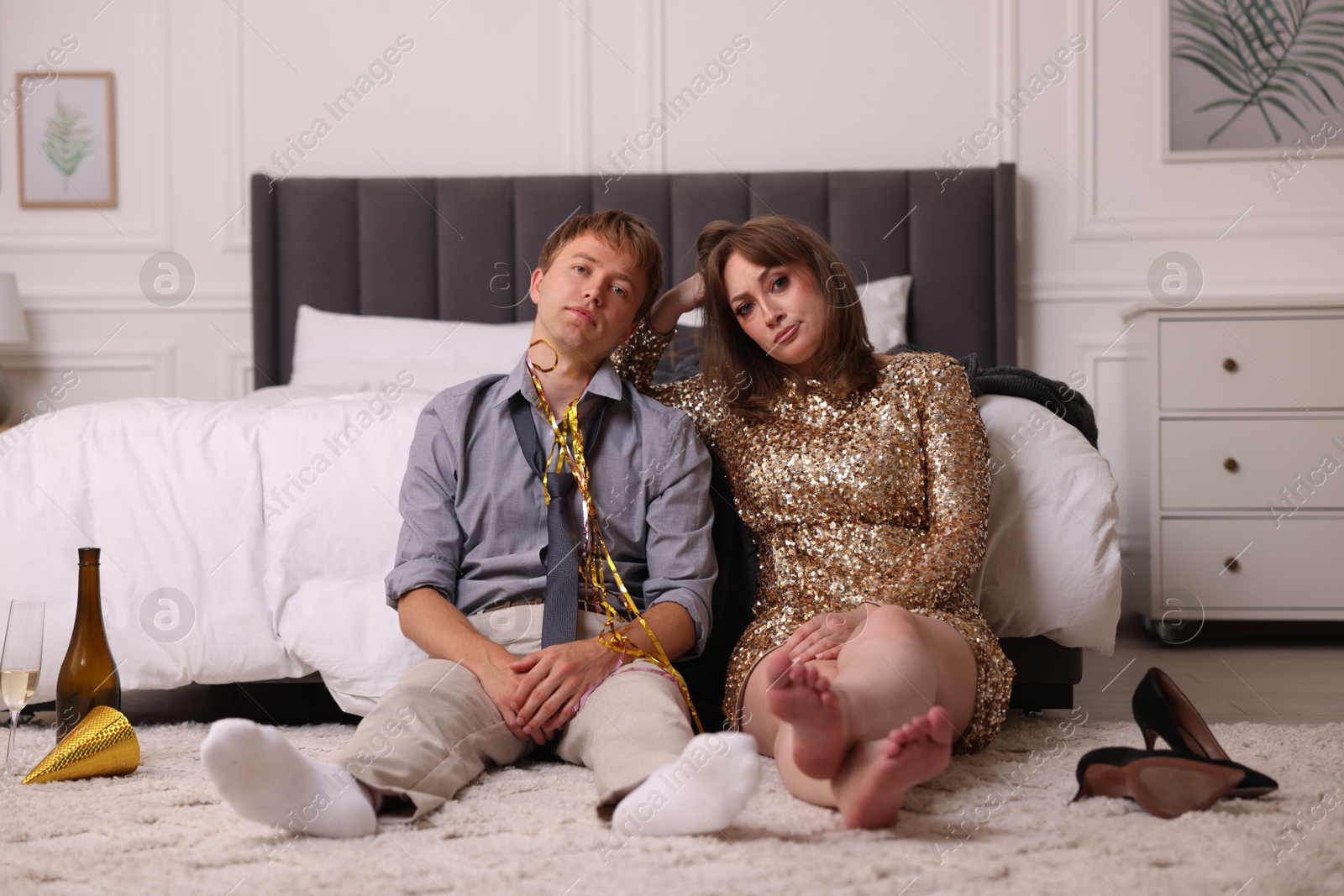 Photo of People suffering from hangover near bed indoors