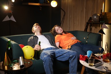 Photo of People suffering from hangover on sofa in messy room after party