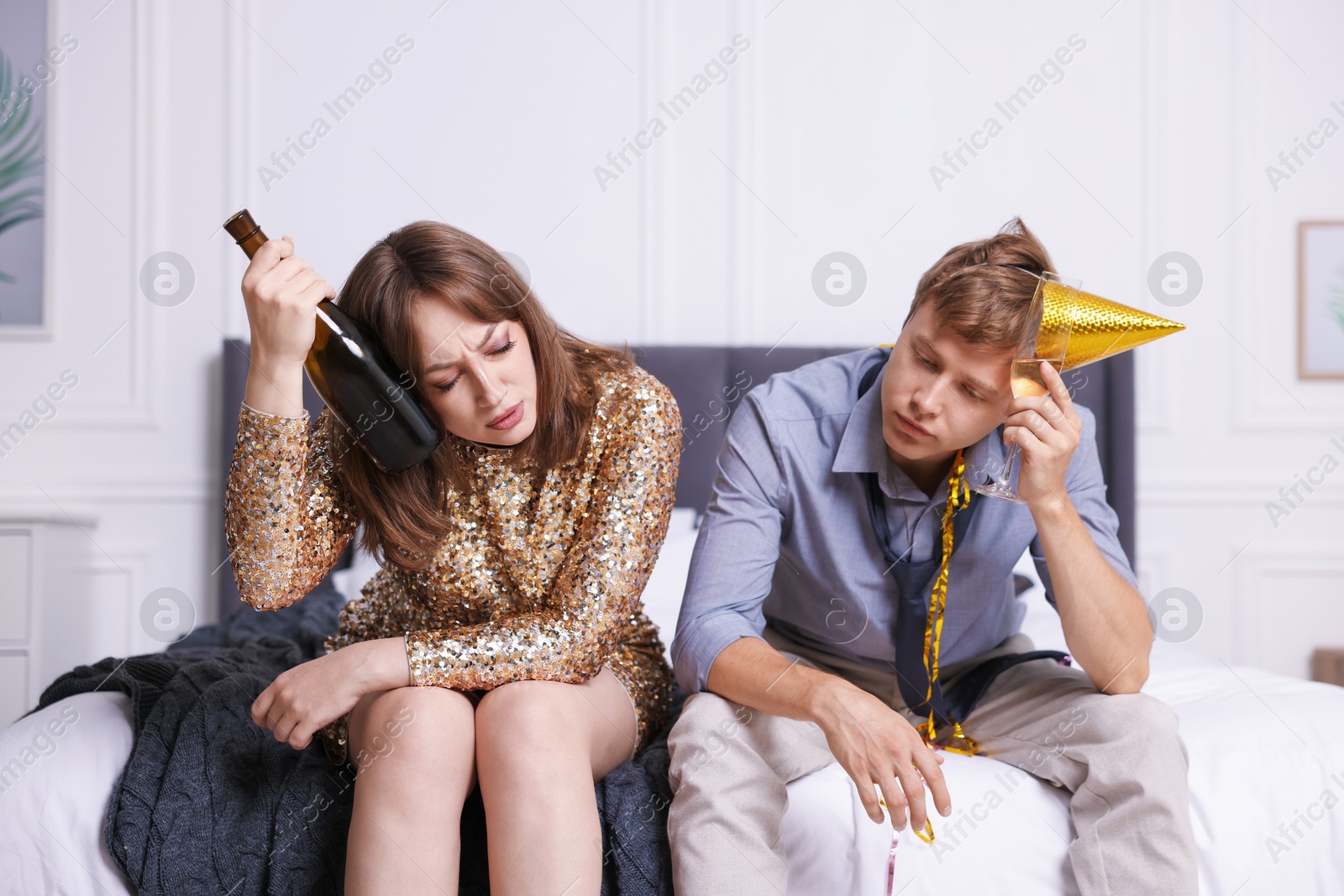 People with alcohol suffering from hangover on bed indoors Photo of People with alcohol suffering from hangover on bed indoors