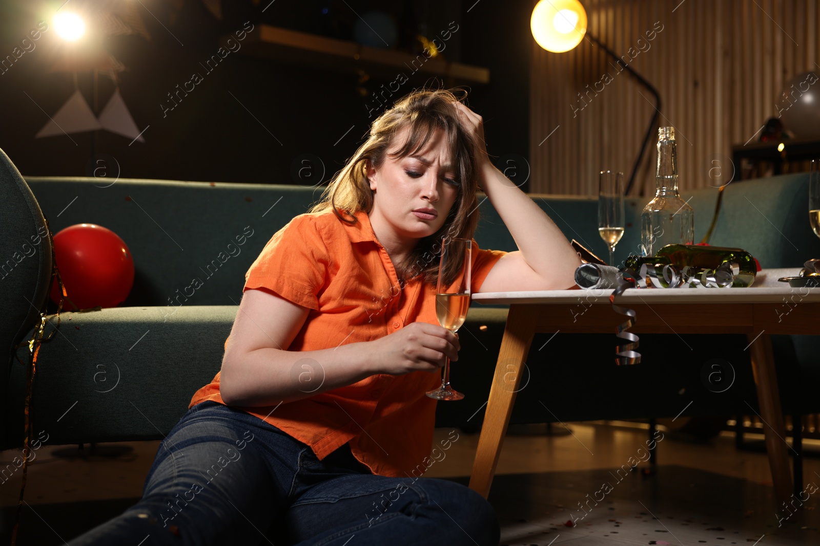 Woman with alcohol suffering from hangover in messy room after party Photo of Woman with alcohol suffering from hangover in messy room after party