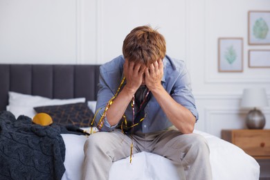 Photo of Man suffering from hangover on bed indoors