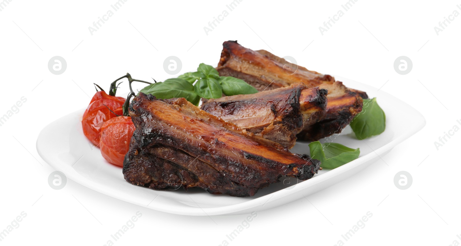 Roasted beef ribs, tomatoes and basil isolated on white Photo of Roasted beef ribs, tomatoes and basil isolated on white