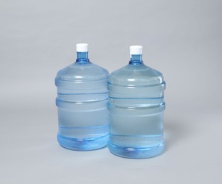 Photo of Cooler bottles with water on light grey background
