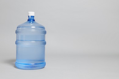 Photo of Cooler bottle with water on grey background. Space for text