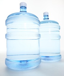Photo of Cooler bottles with water on white background, closeup