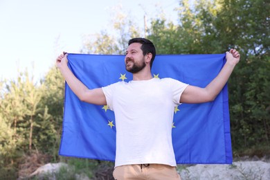 Photo of Smiling man with flag of European Union outdoors
