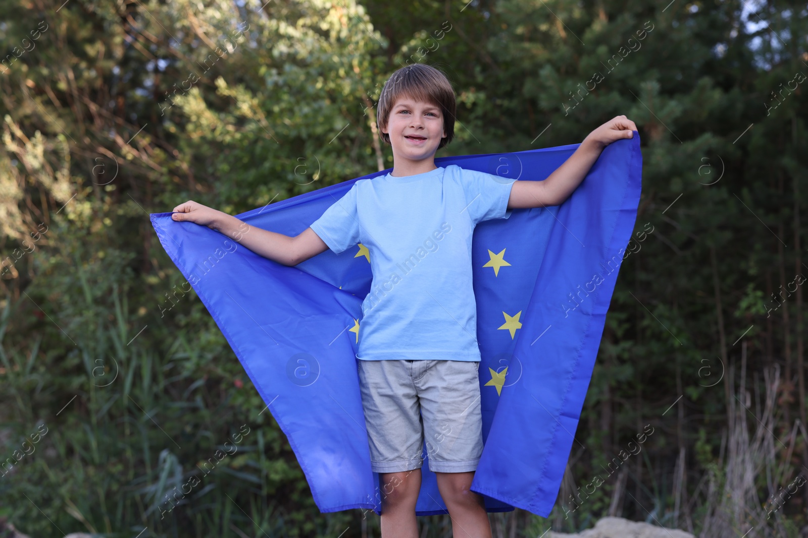 Happy little boy with flag of European Union outdoors Photo of Happy little boy with flag of European Union outdoors