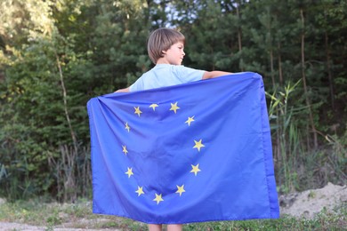 Photo of Little boy with flag of European Union outdoors