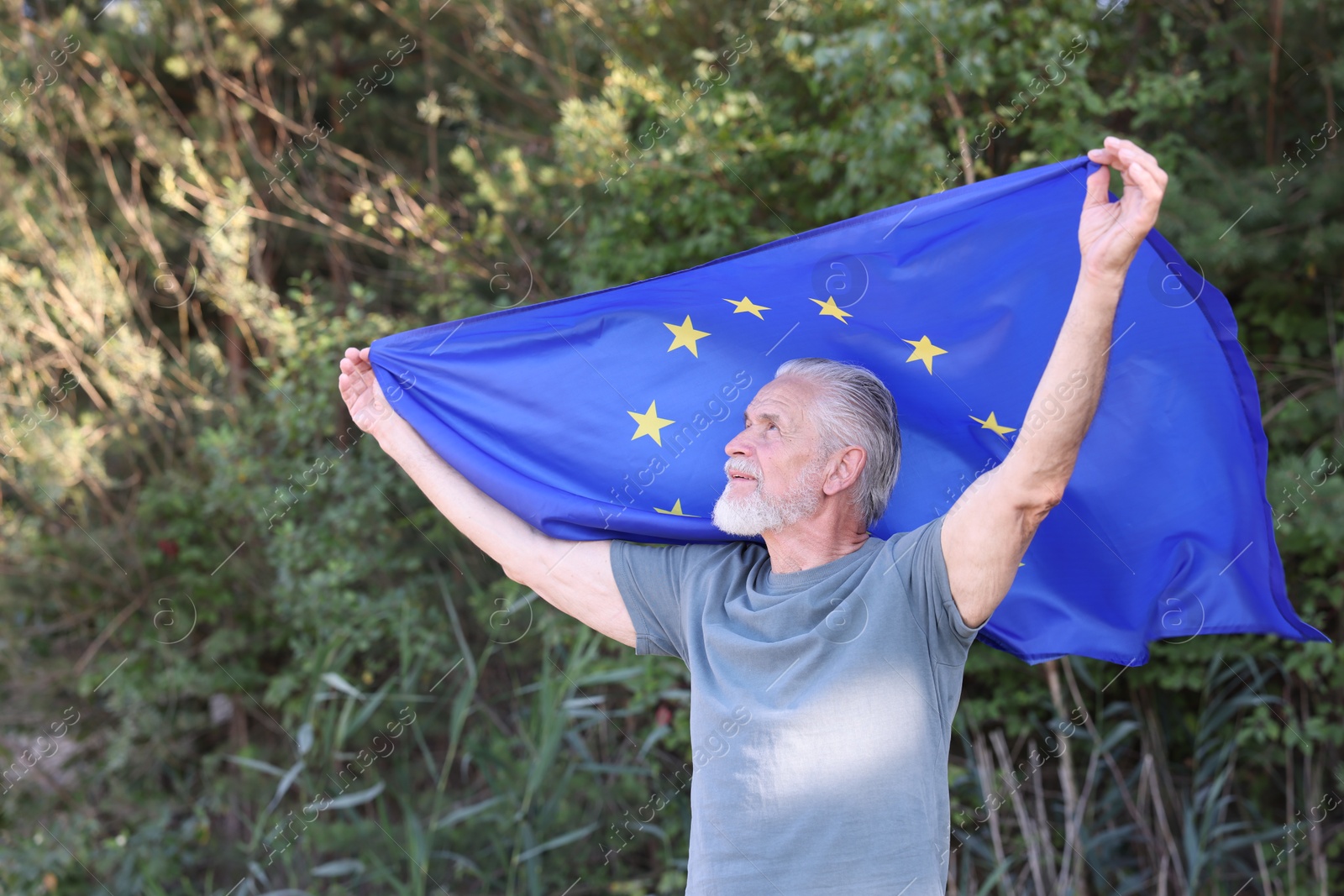 Photo of Smiling elderly man with flag of European Union outdoors