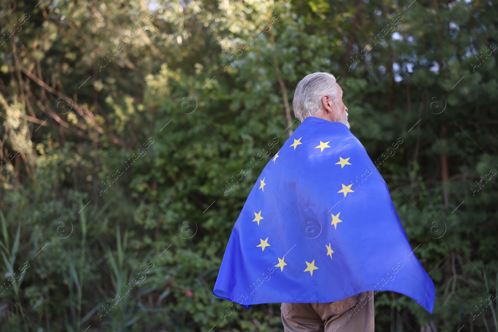 Photo of Elderly man with flag of European Union outdoors. Space for text