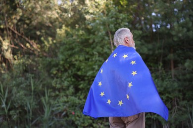 Photo of Elderly man with flag of European Union outdoors. Space for text