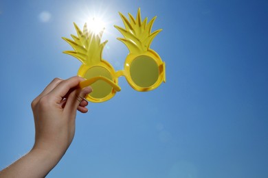 Photo of Woman with funny sunglasses against blue sky on sunny day, low angle view
