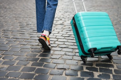 Photo of Goodbye. Woman with luggage walking on city street, closeup