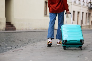 Photo of Goodbye. Woman with luggage walking outdoors, closeup. Space for text