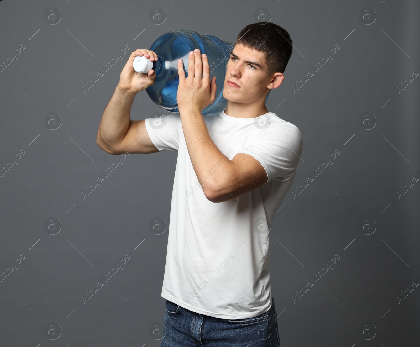 Photo of Delivery man with cooler bottle of water on grey background