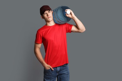 Photo of Delivery man with cooler bottle of water on grey background