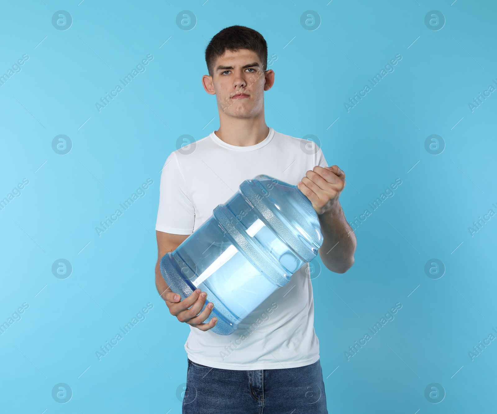 Photo of Delivery man with cooler bottle of water on light blue background