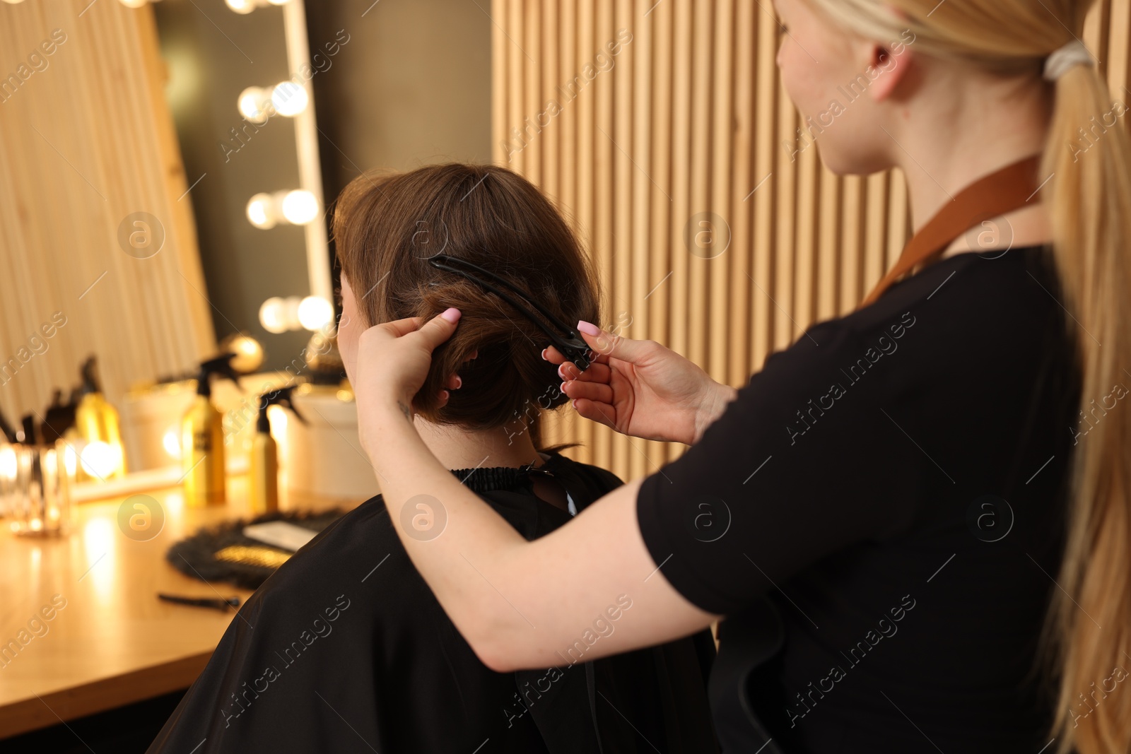 Photo of Hairstylist working with client in salon, closeup