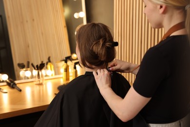 Photo of Hairstylist working with client in salon, closeup