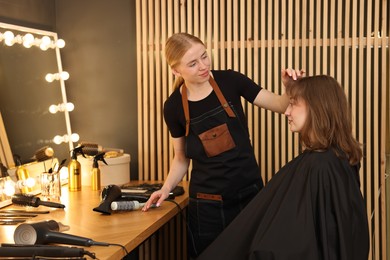Photo of Professional hairstylist working with client in salon