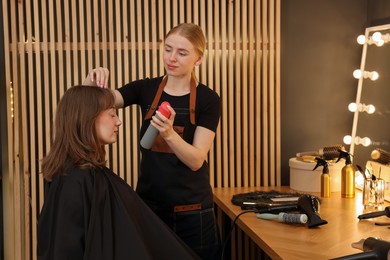Photo of Professional hairstylist working with client in salon
