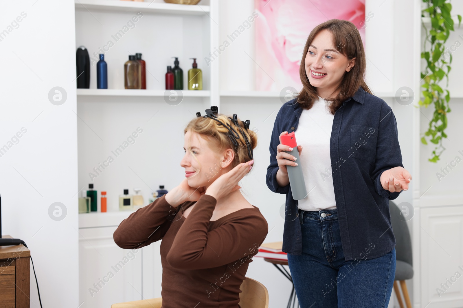 Professional hairstylist working with client in salon Photo of Professional hairstylist working with client in salon