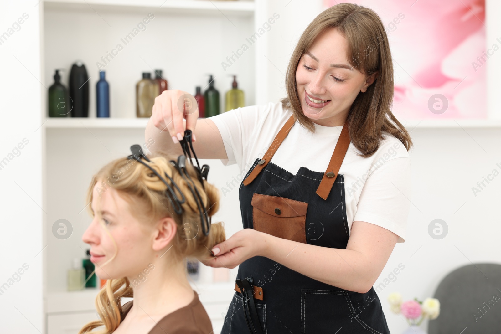 Professional hairstylist working with client in salon Photo of Professional hairstylist working with client in salon