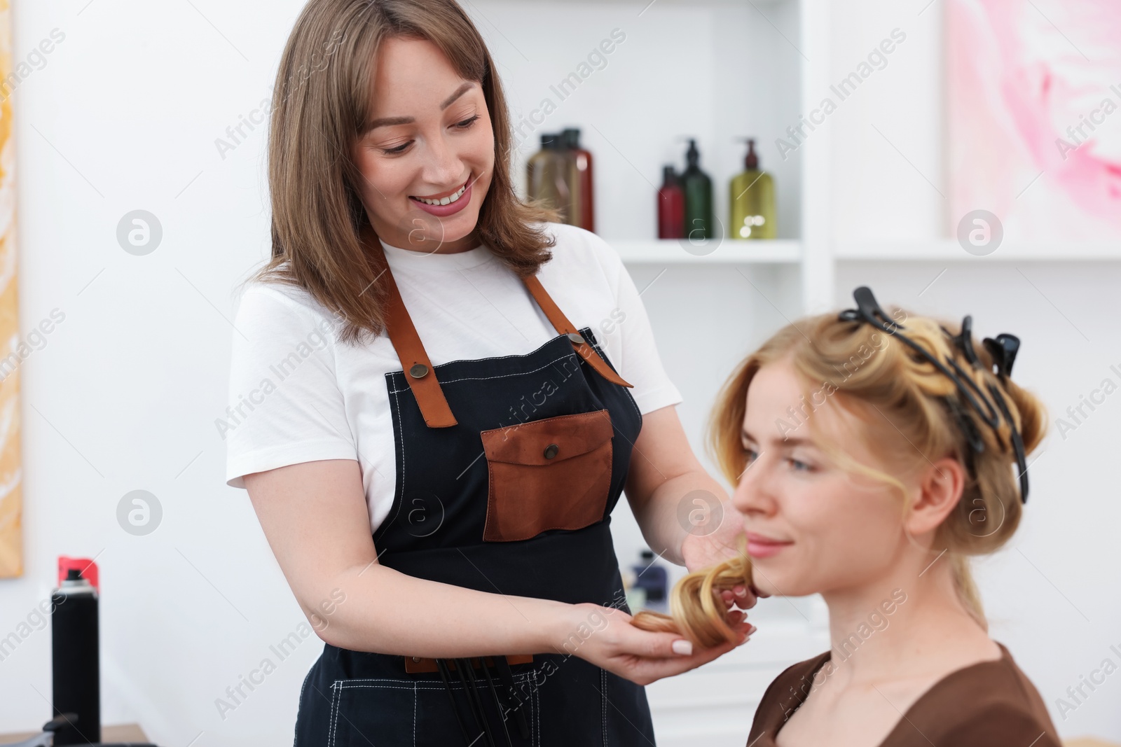 Professional hairstylist working with client in salon Photo of Professional hairstylist working with client in salon