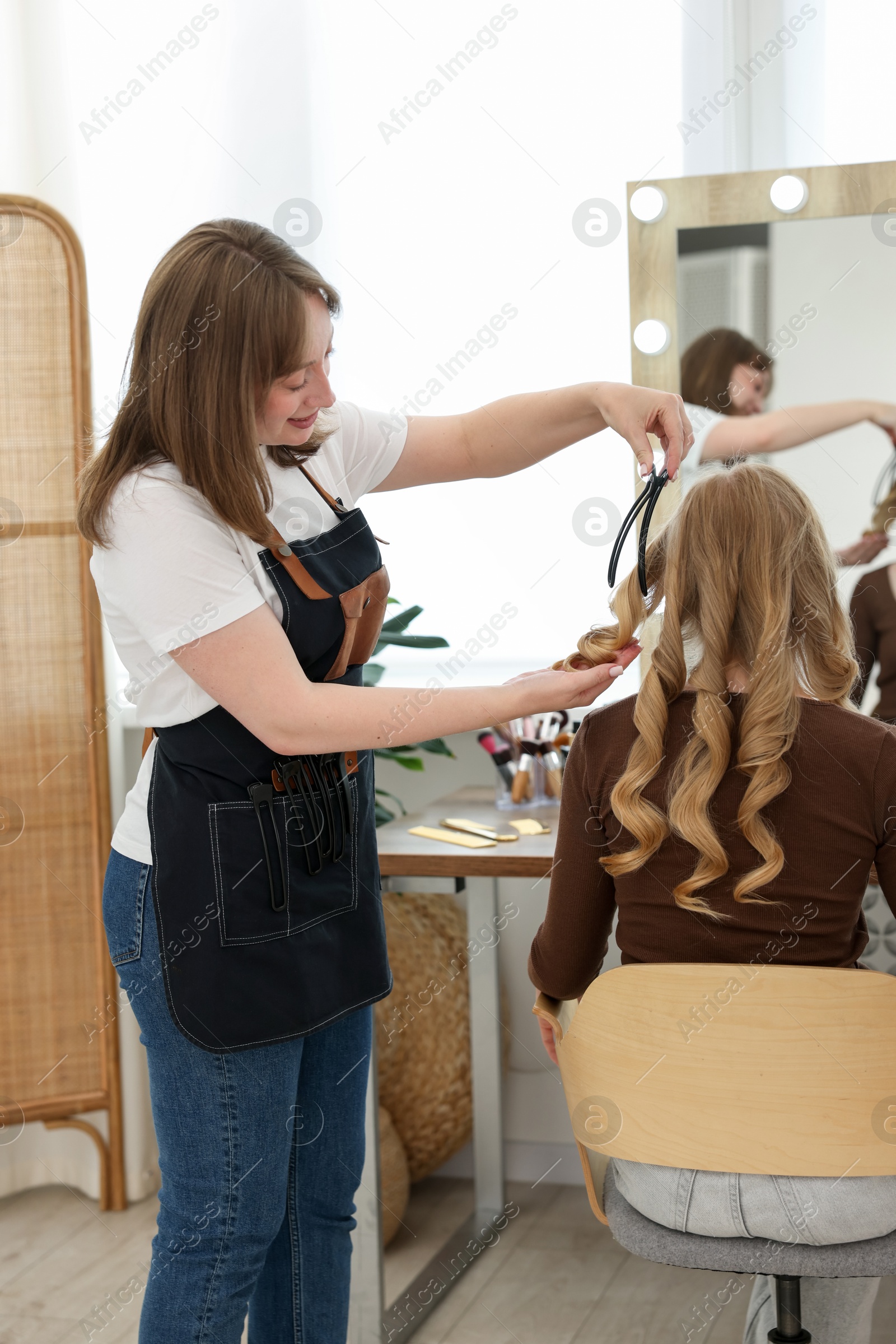 Professional hairstylist working with client in salon Photo of Professional hairstylist working with client in salon