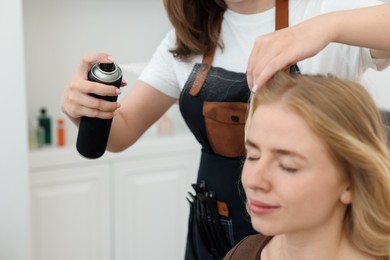 Photo of Professional hairstylist working with client in salon, closeup
