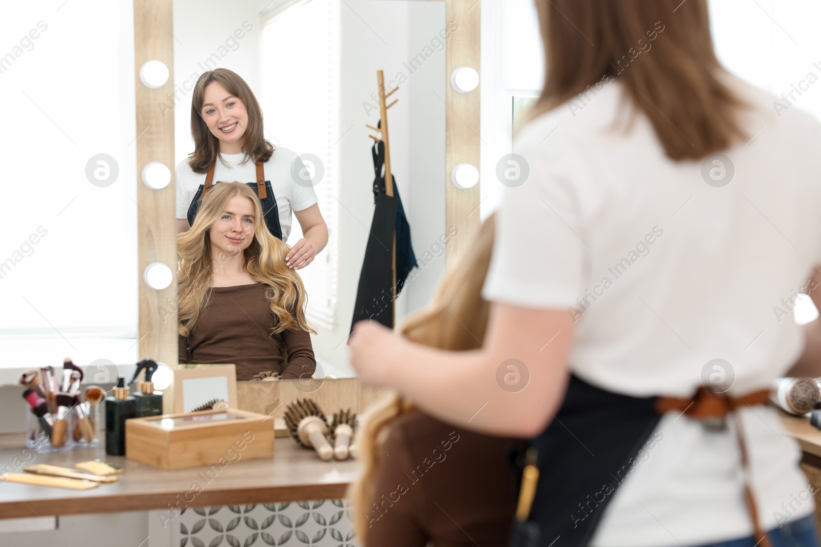 Professional hairstylist working with client in salon Photo of Professional hairstylist working with client in salon