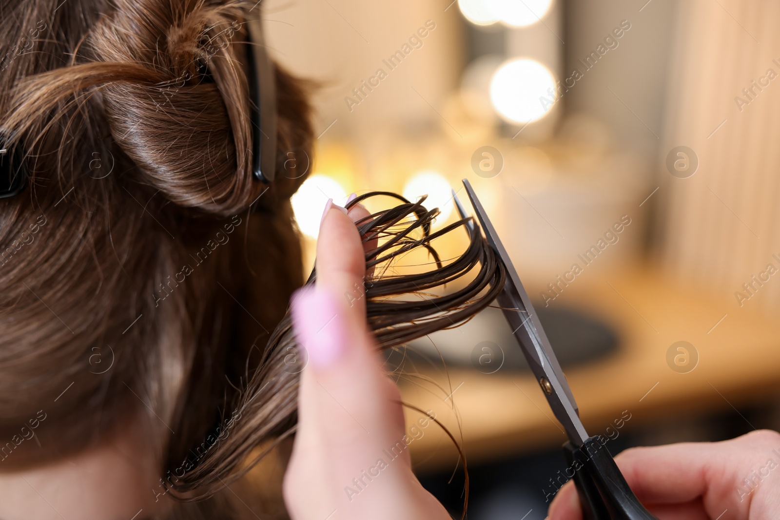Hairstylist cutting client's hair with scissors in salon, closeup Photo of Hairstylist cutting client's hair with scissors in salon, closeup