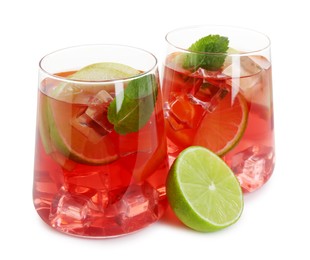 Photo of Tasty punch with ice, mint and slices of lime in glasses isolated on white. Refreshing drink