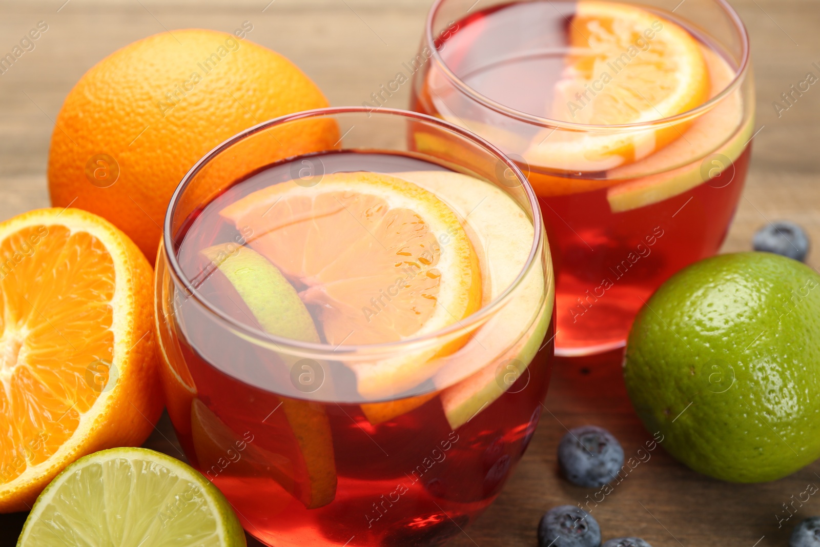 Tasty punch with fruits and blueberries on wooden table, closeup. Refreshing drink Photo of Tasty punch with fruits and blueberries on wooden table, closeup. Refreshing drink