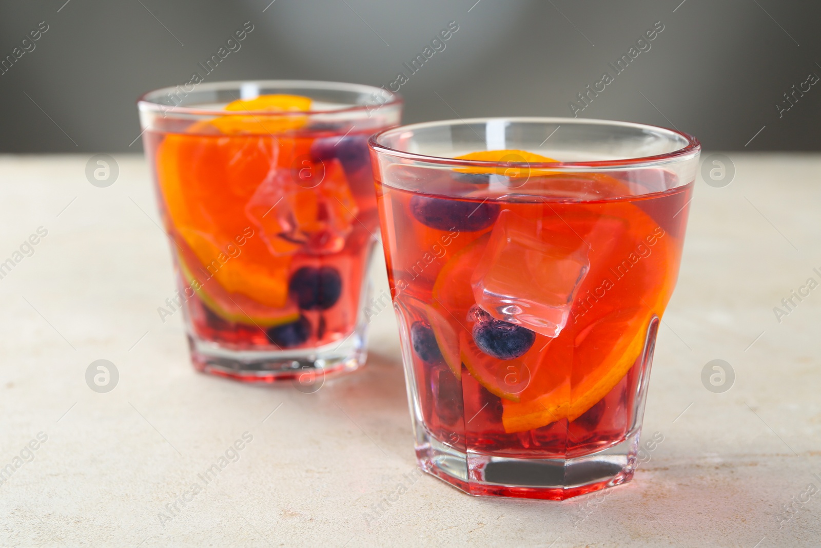 Tasty fruity punch in glasses on light gray textured table, closeup Photo of Tasty fruity punch in glasses on light gray textured table, closeup