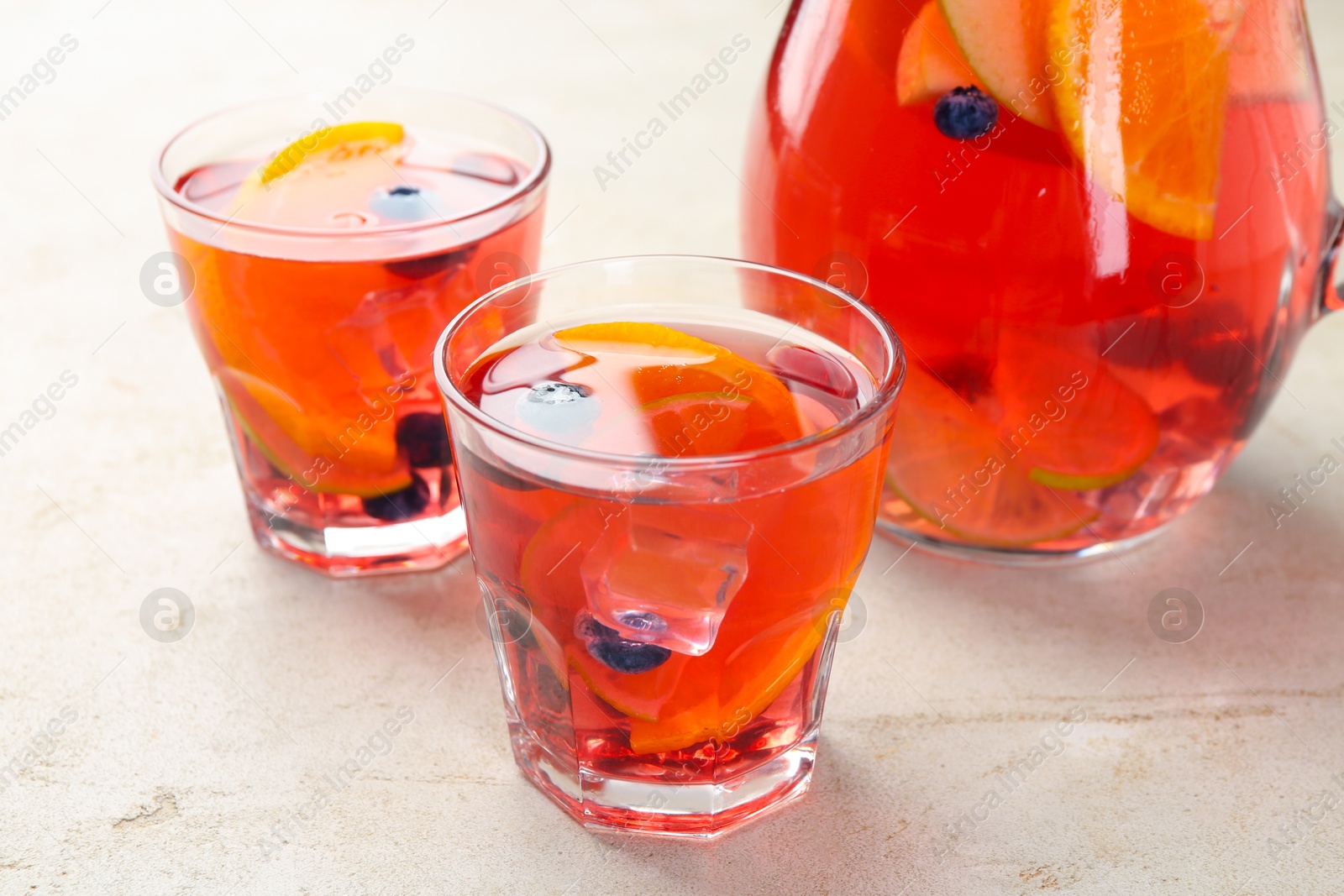 Tasty fruity punch on light gray textured table, closeup Photo of Tasty fruity punch on light gray textured table, closeup
