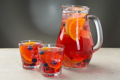 Photo of Tasty fruity punch on light gray textured table