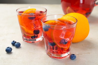 Photo of Tasty fruity punch on light gray textured table, closeup